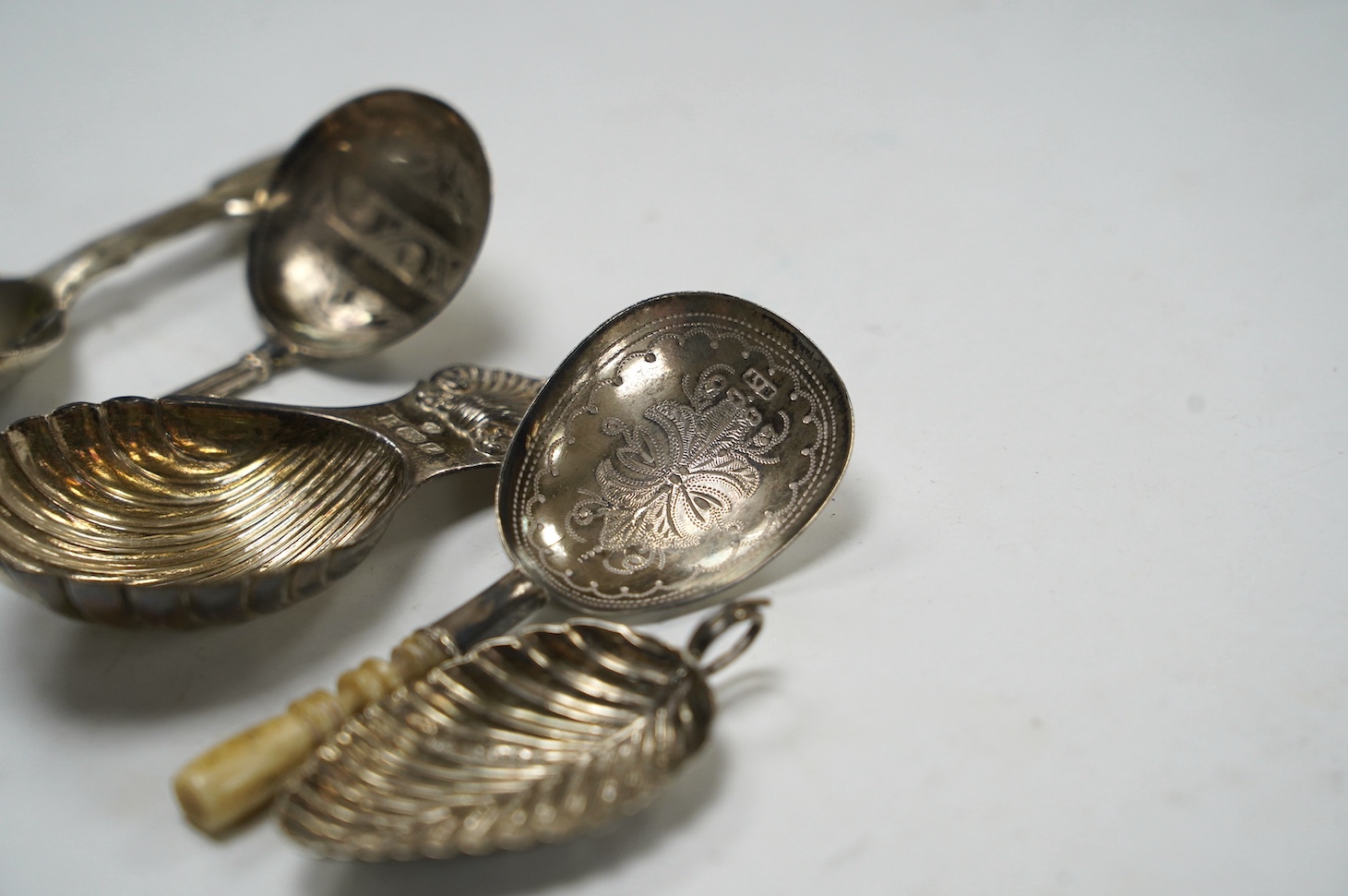 Five assorted silver caddy spoons, including fiddle pattern by Hayne & Cater, London, 1843, foliate terminal handled by George Unite, Birmingham, 1845, bone handled by Hilliard & Thomason, Birmingham, 1879, modern shell